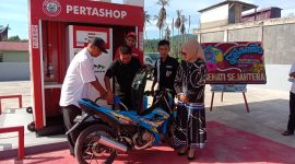 Terlihat Walinagari Parambahan Robi Yasdi mengisi kan BBM ke sepeda motor salah seorang  konsumen.