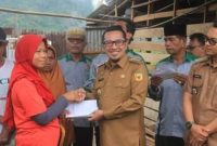 Bupati Tanah Datar Eka Putra menyerahkan bantuan krpada salah satu korban angin beliung Padangganting.
