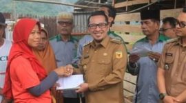 Bupati Tanah Datar Eka Putra menyerahkan bantuan krpada salah satu korban angin beliung Padangganting.
